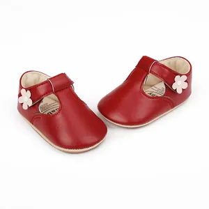Macro detail of red baby girl princess shoes with decorative flower and soft leather finish