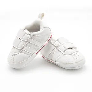 Detailed view of white baby walking shoes with anti-slip soles and breathable faux leather.