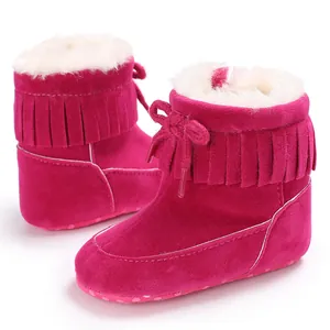 Detailed view of pink baby snow boots with stylish fringe and warm fleece interior.