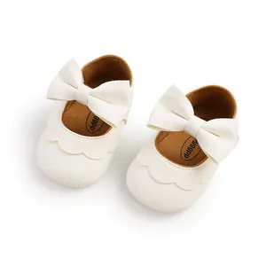 Detailed close-up of white PU leather baby princess shoes featuring large bow and scalloped edges