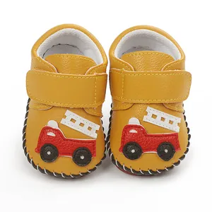 Détail de chaussures de marche jaunes pour bébé avec semelles cousues main et camion