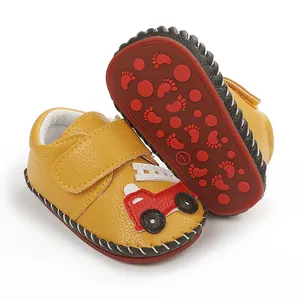 Détail rapproché de chaussures de marche bébé jaunes antidérapantes avec motif voiture