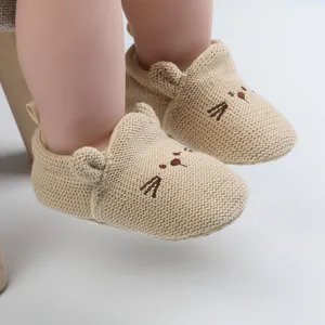 Detail of soft knit baby walker shoes with cute cartoon cat face embroidery