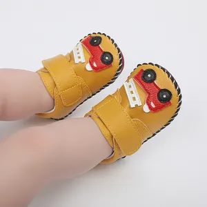 Vue détaillée de chaussures de marche pour bébé jaunes avec motif voiture rouge.