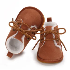 Braune, gefütterte Baby-Lauflernschuhe mit weißem Kunstfell und einer Gummisohle.