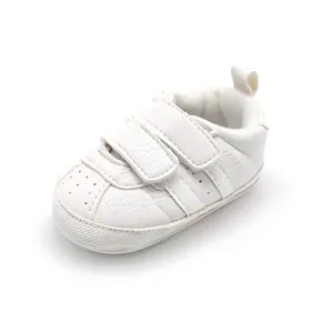 Close-up of white baby walking shoes with anti-slip rubber soles and velcro straps