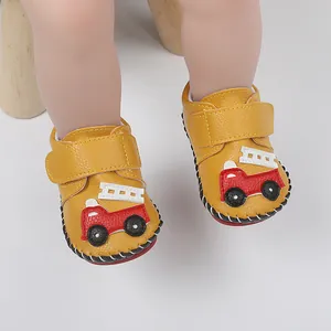 Détail de chaussures de marche jaunes pour bébé avec camion de pompier et couture à la main