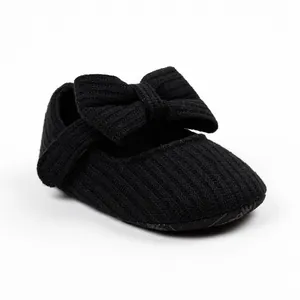 Detailed view of black knitted baby girl walker shoe with a decorative large bow