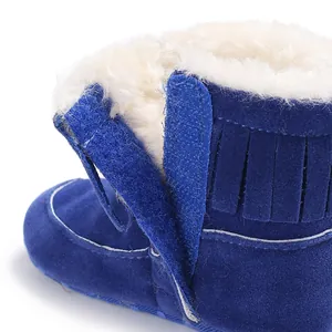 Detailed view of blue baby snow boots with white faux fur lining and velcro strap closure
