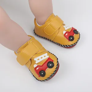 Vue détaillée de chaussures bébé jaunes avec écusson voiture et fermeture velcro.