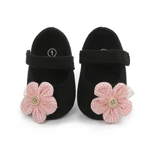 Primer plano de zapatos negros de bebé para niña con una flor decorativa de cuadros rosas
