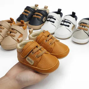 Close-up view of premium soft-sole baby boy walker sneakers held in hand for scale