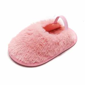Primo piano di pantofole rosa in peluche per neonati con cinturino elastico sul tallone