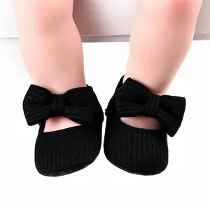 Detailed macro shot of black knit baby walker shoes featuring a large decorative bow