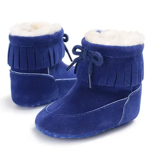 Detailed close-up view of blue fringe baby snow boots with warm white faux fur lining