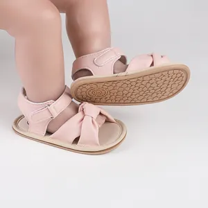 Close-up detail of pink baby prewalker sandals with anti-slip rubber sole and bow design