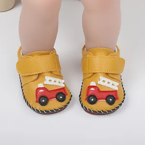 Vue détaillée de chaussures de marche jaunes pour bébé avec motif de camion de pompiers
