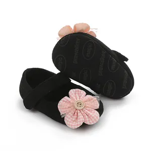 Detalle de zapatos de primeros pasos para bebé con adorno de flor de cuadros en rosa