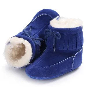 Close-up of blue baby winter snow boots with soft white fleece lining and fringe detail