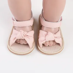 Detailed close-up view of pink baby walking sandals featuring a large soft bow design.