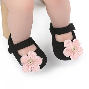 Close-up of baby girl Mary Jane shoes with pink plaid flower and button detail.