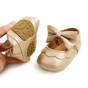 Detailed view of baby girl gold princess shoes with soft rubber sole and large bow