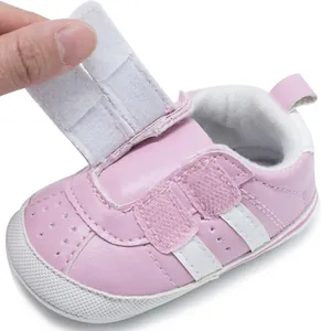 Close-up detail of pink baby walking shoe featuring adjustable hook-and-loop strap closure