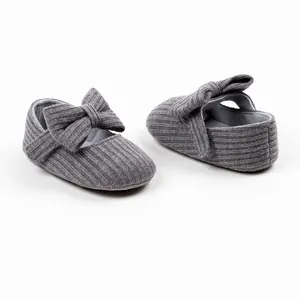 Detail view of grey knitted baby girl pre-walker shoes featuring a soft ribbon bow