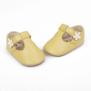 Adorable yellow baby Mary Jane shoes featuring white flower decor and soft rubber soles