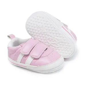Close-up of pink baby walking shoes with dual velcro straps and anti-slip rubber soles.