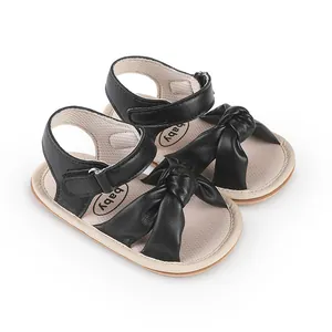 Close-up view of black baby walking sandals featuring a soft bow-knot and velcro straps