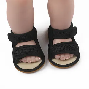 Vorderansicht Detail von schwarzen Mesh-Babysandalen mit doppeltem Klettverschluss am Puppenfuß
