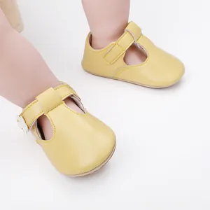 Detail view of yellow baby girl princess shoes with floral accent for 0-1 year olds