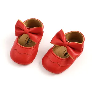 Detail view of red PU leather baby princess shoes with large decorative bows and soft soles
