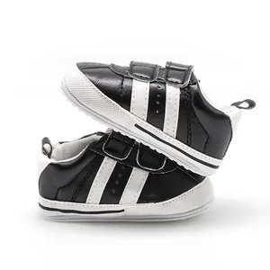 Side view of black and white baby toddler shoes with two-strap hook and loop closure