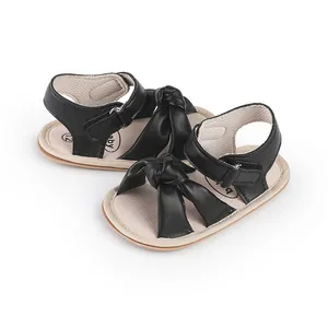 Detailed macro view of black baby walking sandals featuring a soft sole and bow knot