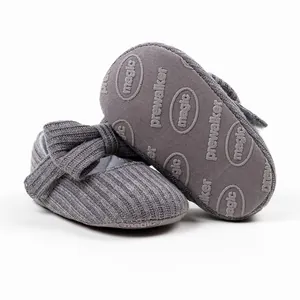Detailed view of grey knitted baby pre-walker shoes showing bow and non-slip sole texture