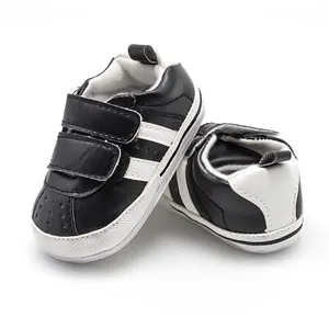 Detail of baby walker shoes featuring black and white design with non-slip rubber sole
