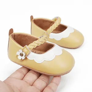 Detailansicht gelber Babylauflernschuhe mit geflochtenem Riemen und weißem Wellenrand