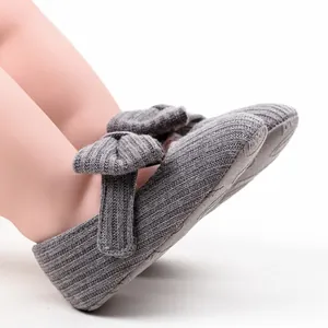 Nahaufnahme graue gestrickte Baby-Prinzessin-Schuhe mit charmanter Schleife für Mädchen