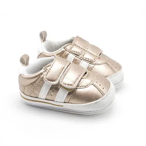Detailed view of elegant champagne gold baby walking shoes with dual strap closure and soft sole