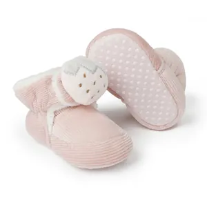 Nahaufnahme von rosa Baby-Boots aus Cord mit Erdbeer-Dekor und weißem Fleecefutter