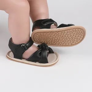 Close-up detail of black baby prewalker sandals featuring a cute bow and anti-slip rubber sole
