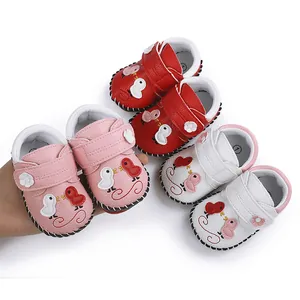 Zapatos de bebé hechos a mano con dibujos de pájaros en rosa, rojo y blanco.