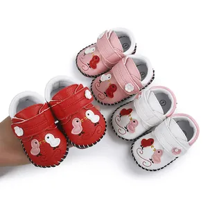 Detalle de zapatos de gateo para bebé hechos a mano con bordado de pájaros en varios colores