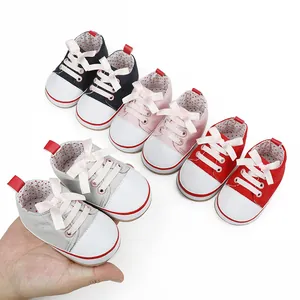 Detailed view of colorful baby walking shoes with ribbon laces and soft soles.
