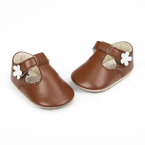 Detailed view of brown baby girl princess shoes featuring a white flower ornament