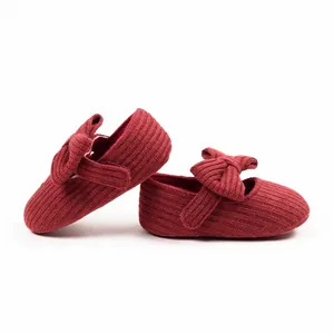 Close-up of red knitted baby Mary Jane walker shoes with elegant bow details for girls.