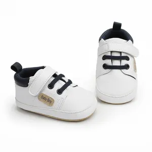 Close-up of white baby walking shoes with dark blue laces and hook-and-loop strap