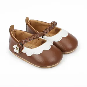 Braune Baby-Lauflernschuhe mit weißem Wellenrand und geflochtenem Riemen-Detail in der Nahaufnahme